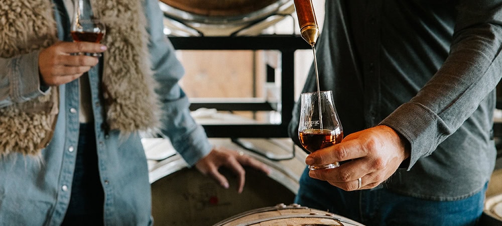 Vast-Creative_Hospitality-Branding-Agency_The-Summit-at-Brush-Creek-Ranch_Agenda-Off-Canvas_Master-Distiller A couple enjoying exceptional whiskey