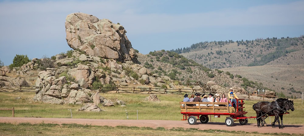 Vast-Creative_Hospitality-Branding-Agency_The-Summit-at-Brush-Creek-Ranch_Agenda-Off-Canvas_The-Art-of-the-Team People experiencing the tradition of wagon driving